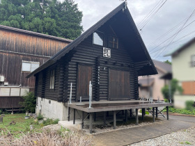 【中古戸建】日高町名色 黒塗りの丸太が重圧感を演出するログハウスですね。(外観)