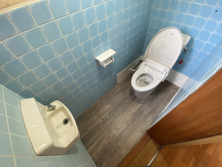 ブルータイルが印象的なトイレ空間。手洗い場も付いており便利ですね。(内装)