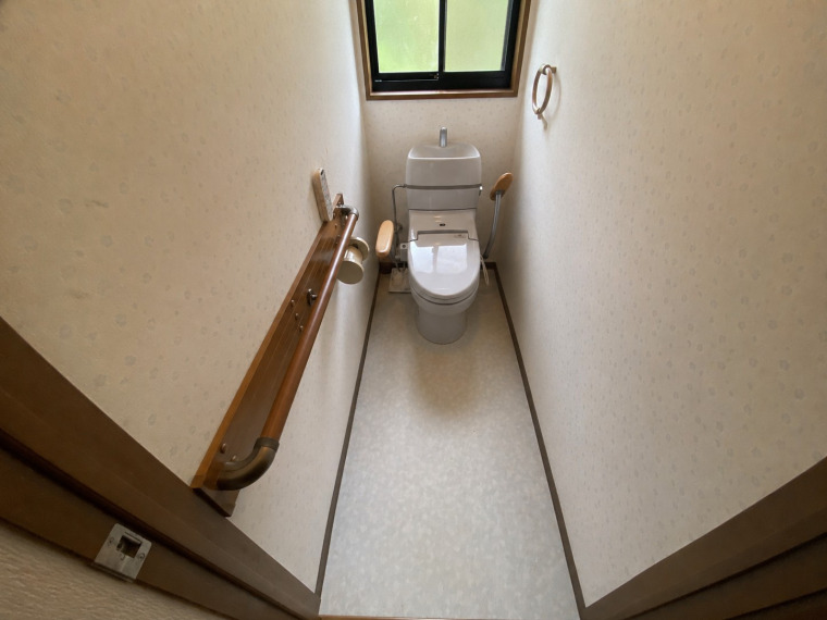 手すりを設置した使いやすいトイレ。将来的にも安心してお住まいいただけます。※この写真はAIの編集を施したものです。(内装)